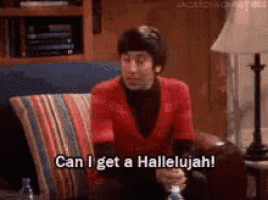 a man in a red shirt is sitting on a couch and saying can i get a hallelujah .