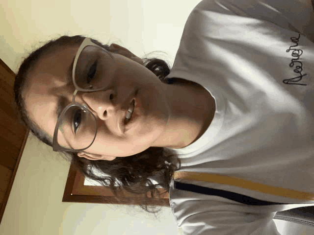 a girl wearing glasses and a white shirt that says abercrombie