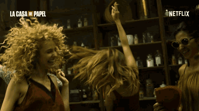 a group of women are dancing in front of a sign that says netflix
