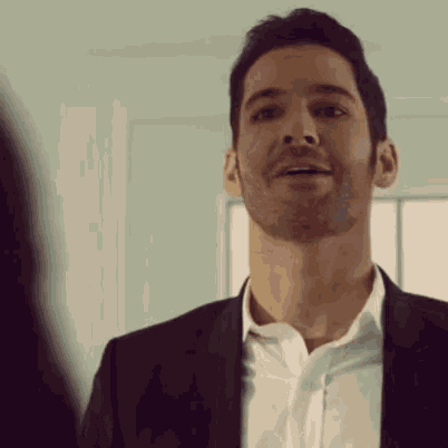 a man with a beard wearing a suit and white shirt is smiling