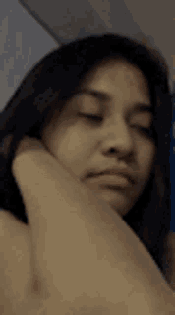 a close up of a woman 's face with a hand on her face .