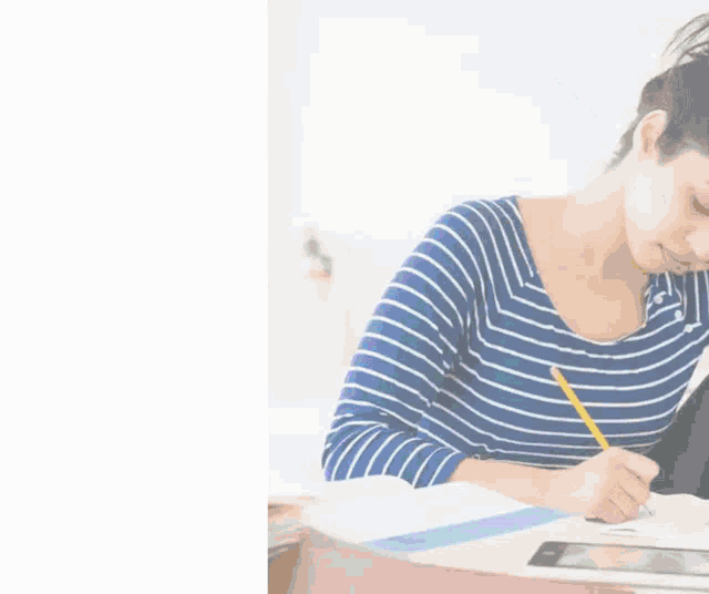 a woman sits at a desk in front of a sign that says alliance academy.in