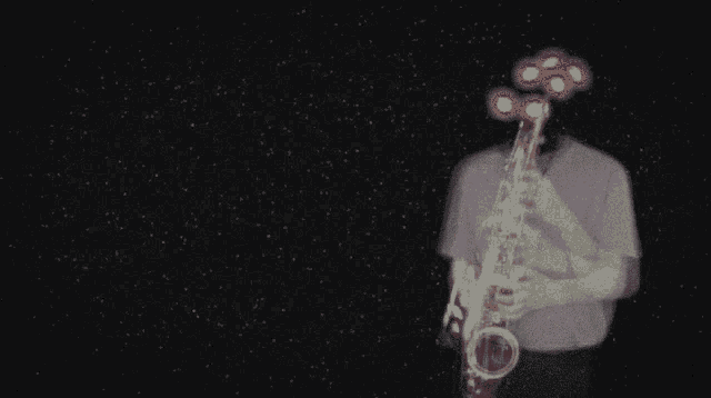 a man playing a saxophone in a dark room with a flower in the background