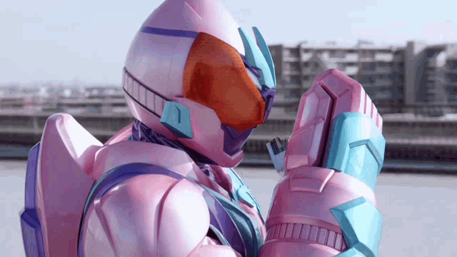 a pink and purple robot with a helmet and gloves is standing on a rooftop .