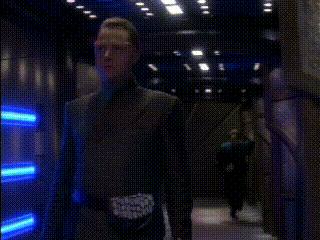 a person is standing in front of a blue light on a wall .