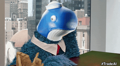 a stuffed animal with a whale head sits at a table with a sign that says tradeal