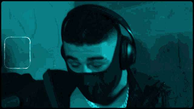 a man wearing headphones and a mask is in a blue light