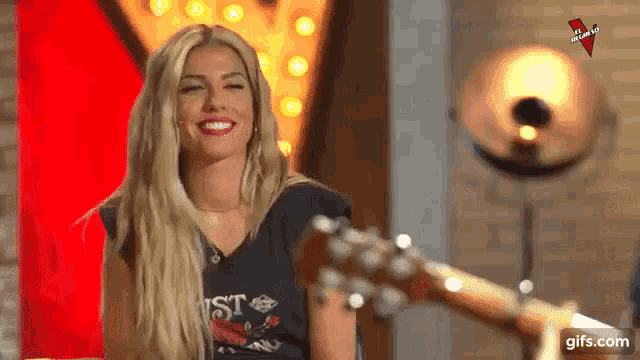 a woman is sitting in a chair with a guitar in front of her .