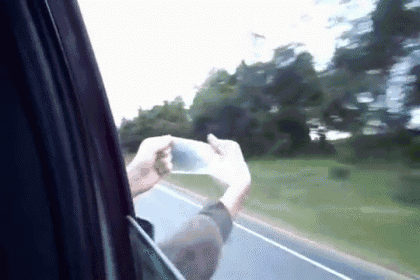 a person taking a picture out of a car window while driving down a road