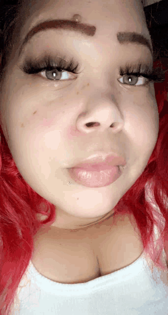 a woman with red hair is taking a selfie