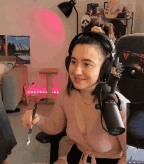 a woman is wearing headphones and holding a pen