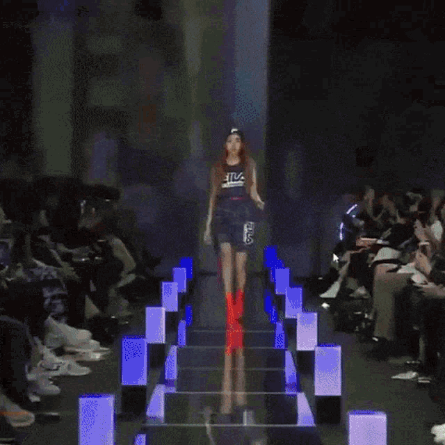 a woman wearing red boots walks down stairs