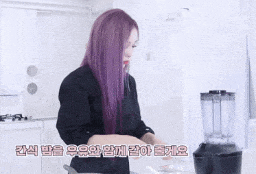 a woman with purple hair cooking in a kitchen