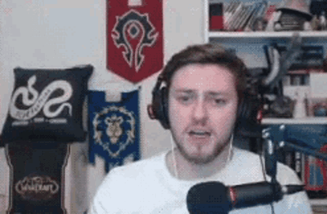 a man wearing headphones is talking into a microphone in a room .