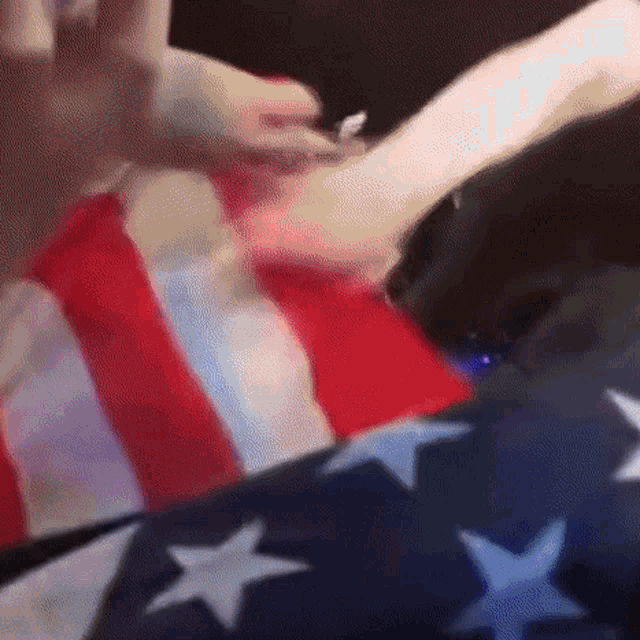 a person is laying on a bed with a red white and blue american flag .