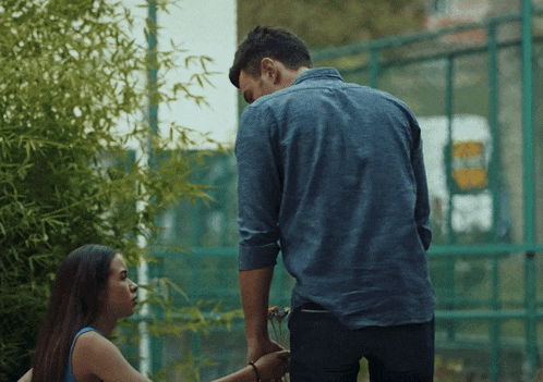 a man in a blue shirt is standing next to a woman in a blue shirt