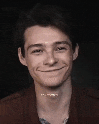 a close up of a young man 's face with a smile on it .