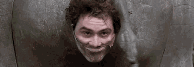 a man with duct tape on his mouth is standing in front of a wall .