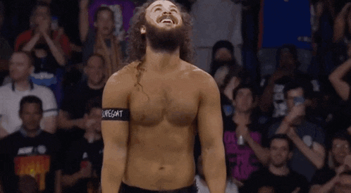 a bearded wrestler with a band around his waist that says suregoat