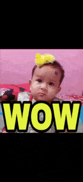a baby with a yellow bow on her head is standing in front of the word wow
