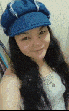 a woman is wearing a blue hat and smiling
