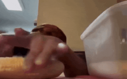 a close up of a person eating a hamburger on a table