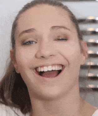 a close up of a woman 's face with her eyes closed and her mouth open