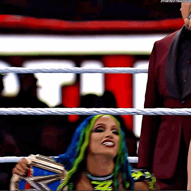a woman in a wrestling ring holding a championship belt