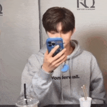 a young man wearing a hoodie that says vonterwall is looking at his phone