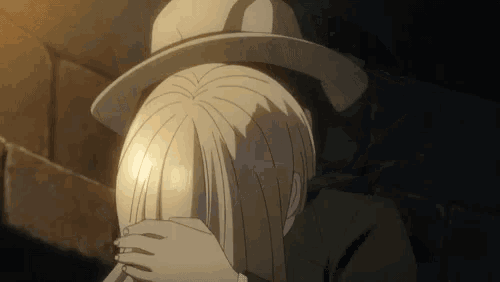 a man in a hat is covering a woman 's face with his hands .