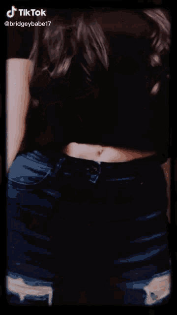 a woman wearing sunglasses and a crop top has a tiktok watermark on the bottom