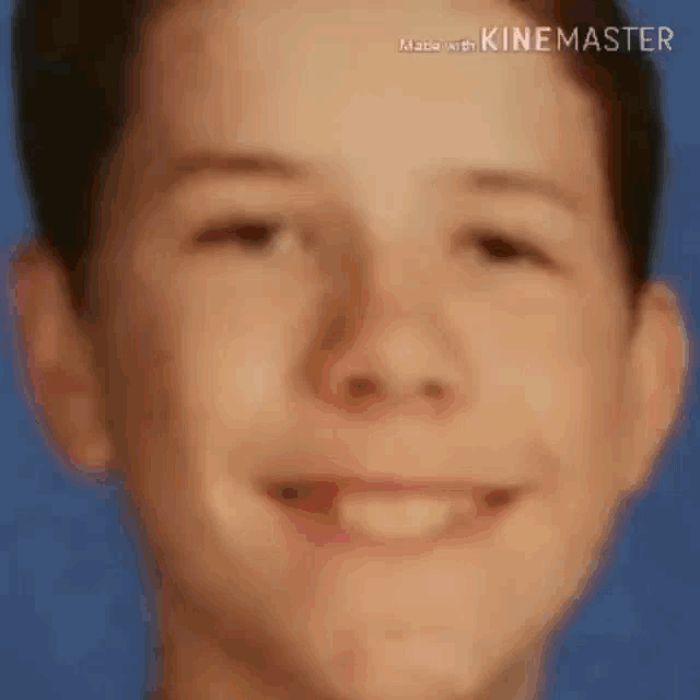 a close up of a young boy 's face with a smile .