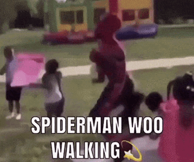 a man in a spiderman costume is walking with a group of children