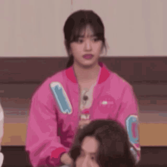 a woman in a pink jacket is sitting next to a man in a chair .