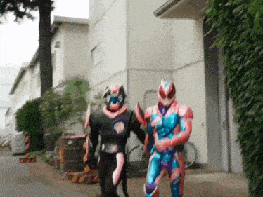 two superhero costumes are walking down a street in front of a building .