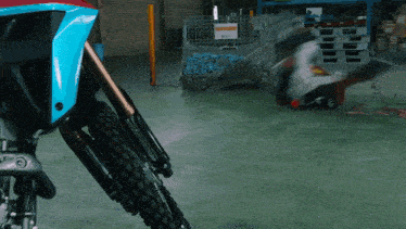 a motorcycle is parked in a warehouse with a sign on the wall that says ' warehouse '