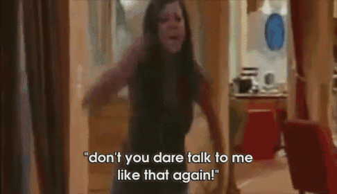 a woman is standing in a room and saying " don 't you dare talk to me like that again " .