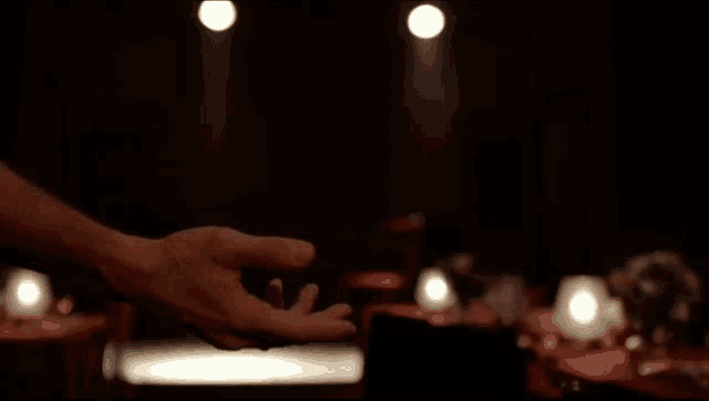 a man and a woman are holding hands in a dark room