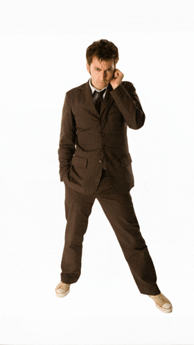 a man in a suit and tie stands with his hands in his pockets