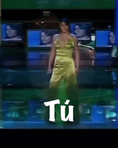 a woman in a yellow dress is singing into a microphone with the word tu in white letters behind her