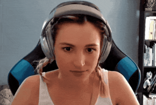 a woman wearing headphones is looking at the camera