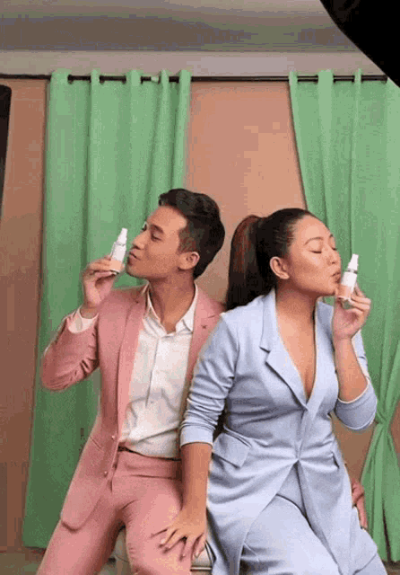 a man in a pink suit is kissing a woman in a blue dress