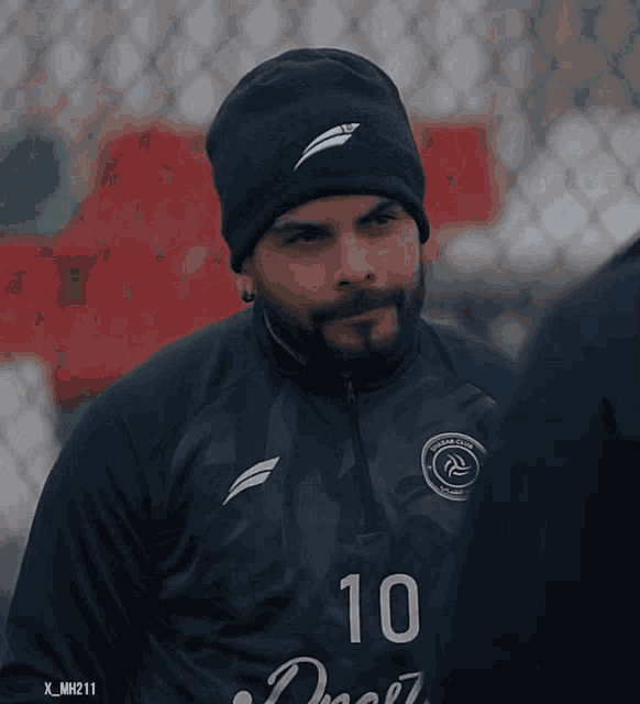 a man wearing a hat and a jersey with the number 10