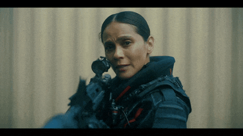 a woman holding a rifle with a scope on her head