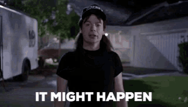 a man in a black shirt and hat is standing in front of a house with the words `` it might happen '' .