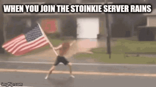 a man holding an american flag on the side of a road .