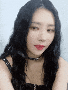 a close up of a woman 's face with a choker around her neck