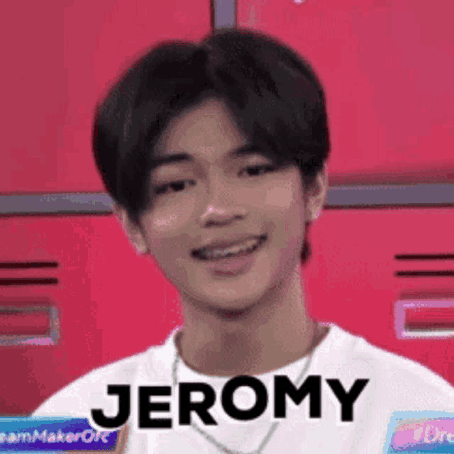 a young man with braces on his teeth is smiling and wearing a white shirt with the name jeromy written on it .
