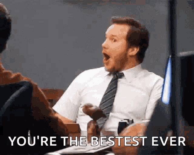 a man in a white shirt and tie is sitting at a desk with his mouth open and says `` you 're the bestest ever ''