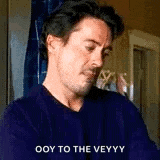 a man in a blue shirt is sitting in a room and says `` ooy to the veyyy '' .